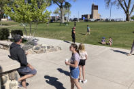 Families flocked to a public park in downtown Los Alamos, N.M., on Thursday, May 12, 2022, during a weeklong public school closure because of nearby wildfire. The blaze crept has been creeping closer to the mesa-top city and companion Los Alamos National Laboratory that analyzes global threats of disease, warfare and natural disasters. Scientists at Los Alamos are using supercomputers and ingenuity to improve wildfire forecasting and forest management amid drought and climate change in the American West. (AP Photo/Morgan Lee)