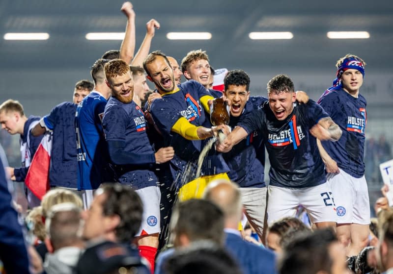 Kiel players celebrate promotion after the German 2nd Bundesliga soccer match between Holstein Kiel and VfL Fortuna Duesseldorf at the Holstein Stadium. Axel Heimken/dpa