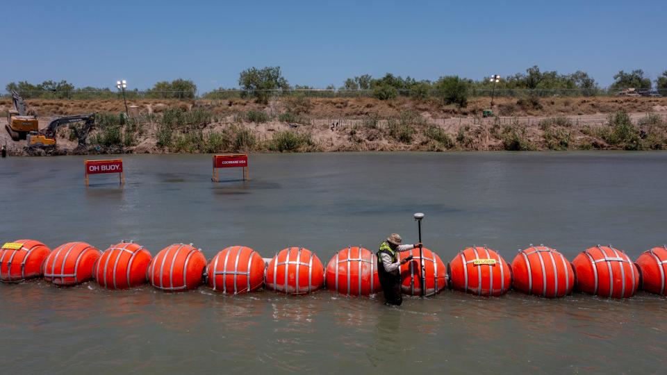 Buoys float on the Rio Grande River in Eagle Pass, Texas, Thursday as a Mexican engineer with the International Boundary and Water Commission uses GPS determine to see if the buoys are crossing into Mexican territory.