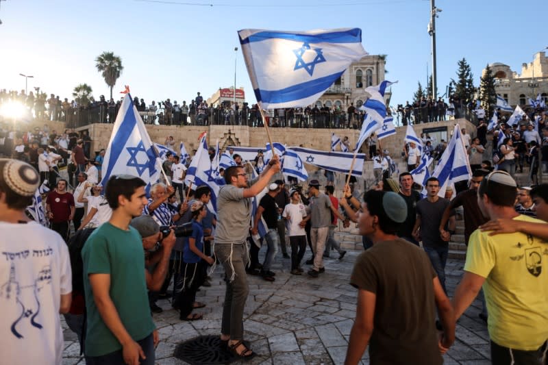 Israelíes bailan con banderas en la Puerta de Damasco, fuera de la Ciudad Vieja de Jerusalén