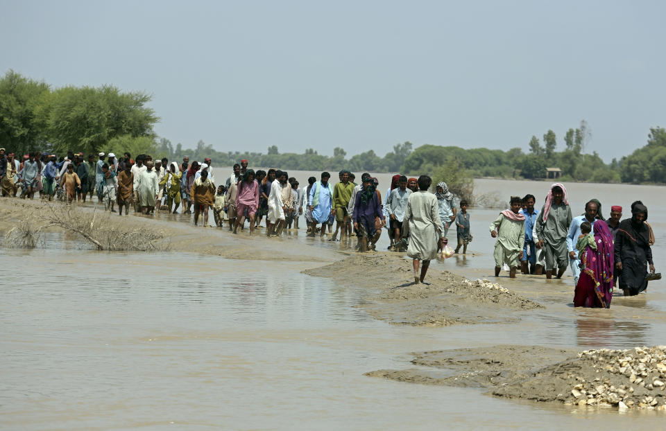 Victims of unprecedented flooding from monsoon rains line up for relief aid organized by the Edhi Foundation, in the Ghotki District of Sindh Pakistan, Wednesday, Sept. 7, 2022. (AP Photo/Fareed Khan)