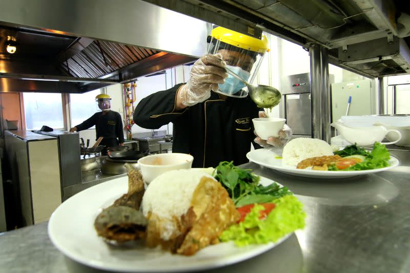 A chef wearing a face shield and protective mask prepares food at a hotel, amid the coronavirus disease (COVID-19) outbreak in Banyuwangi