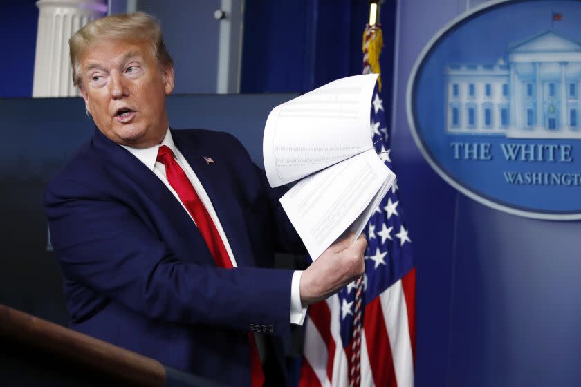 FILE - President Donald Trump holds up papers as he speaks about the coronavirus in the James Brady Press Briefing Room of the White House, April 20, 2020, in Washington. President Joe Biden is ordering the release of Trump White House visitor logs to the House committee investigating the riot of Jan. 6, 2021, once more rejecting former President Donald Trump's claims of executive privilege. The committee has sought a trove of data from the National Archives, including presidential records that Trump had fought to keep private. (AP Photo/Alex Brandon, File)