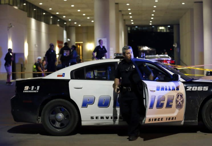 A Dallas police officer steps out of a vehicle as he arrives in front of Baylor University Medical Center where several others were police were already gathered, Friday, July 8, 2016, in Dallas. (AP Photo/Tony Gutierrez)