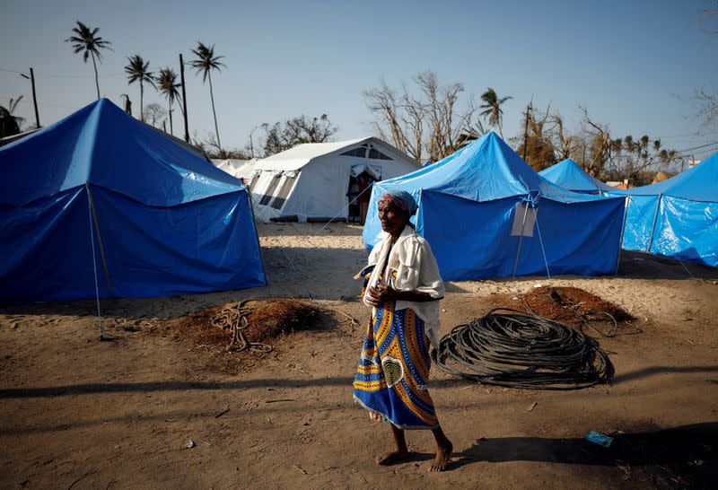 FILE PHOTO: A woman walks past tents in a camp for people displaced in the aftermath of Cyclone Idai in Beira