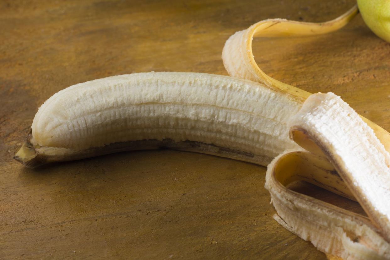 Isolate peeled banana on a yellow Background. Healthy fruit.