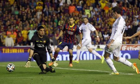 Real Madrid's Gareth Bale scores against Barcelona's goalkeeper Jose Manuel Pinto during their King's Cup final soccer match at Mestalla stadium in Valencia April 16, 2014. REUTERS/Albert Gea