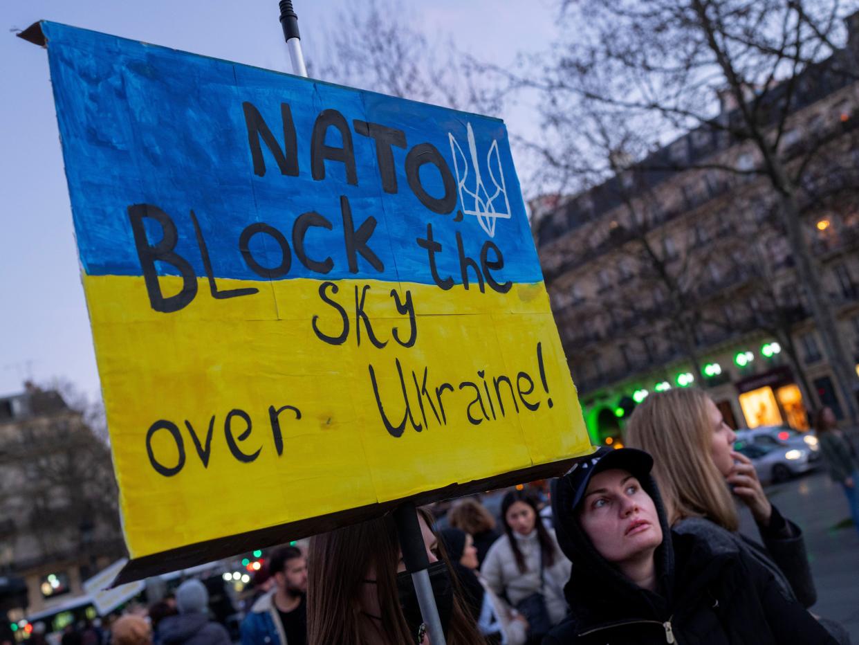 A protestor calls for on NATO to enforce a no-fly zone over the Ukraine during a demonstration in Paris, France, Saturday, Feb. 26, 2022.