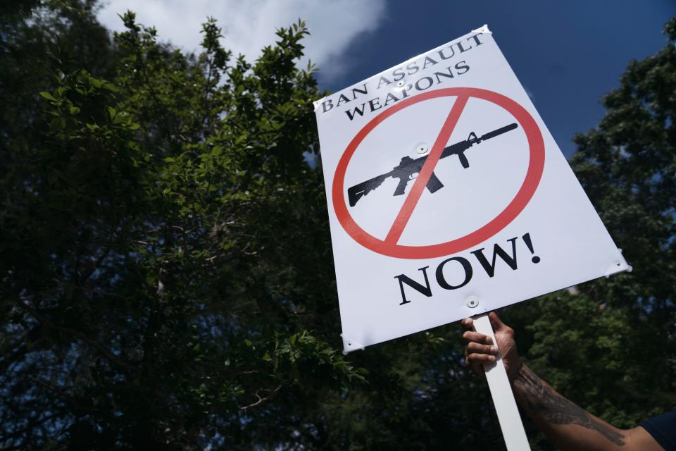 A gun control advocate holds a sign across from the National Rifle Association annual meeting Friday in Houston.