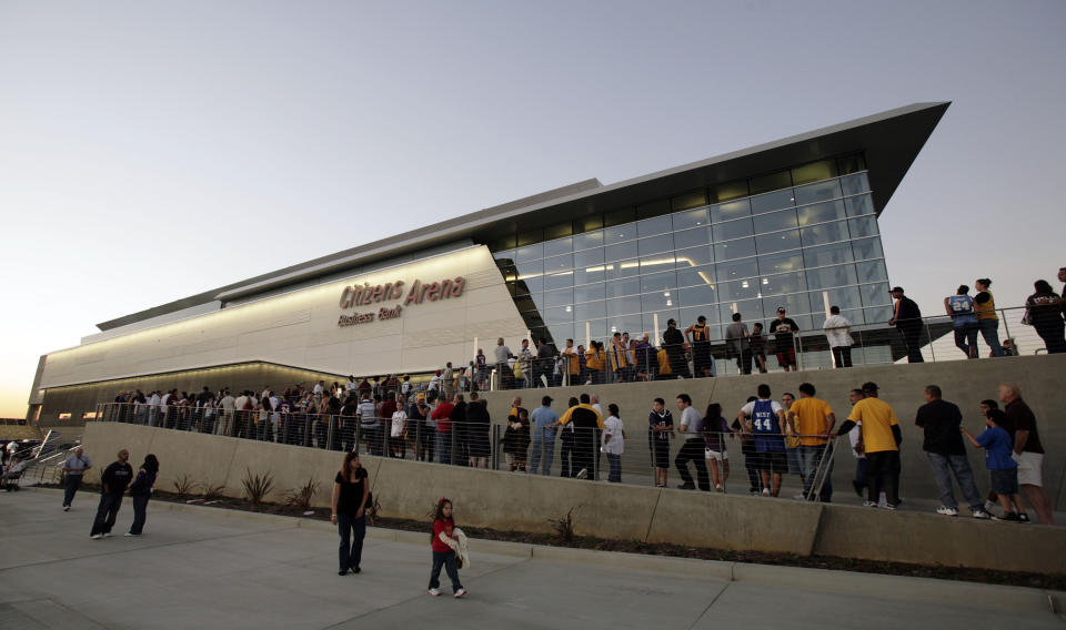 FILE - In this Oct. 24, 2008, file photo, fans line up for the grand opening of the Citizens Business Bank Arena before the Los Angeles Lakers play the Oklahoma City Thunder in an NBA preseason basketball game in Ontario, Calif. The crippling coronavirus pandemic has brought the entire world — including the sports world — to a standstill, and it shows no sign of going away anytime soon. The most obvious change in the short term will be the implementation of social distancing, something that already has permeated everyday life. Ticket sales will be capped and fans will be given an entrance time to prevent crowds at the gate. (AP Photo/Francis Specker, File)