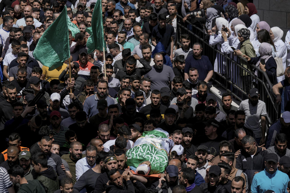 Palestinians carry the bodies of Hassan Qatnani, Moaz al-Masri and Ibrahim Jabr, draped in the Hamas militant group flags, during their funeral in the West Bank city of Nablus, Thursday, May 4, 2023. The Israeli military says it has killed three Palestinians wanted for an attack last month on a car near a Jewish West Bank settlement that killed a British-Israeli mother and two of her daughters. Hamas said the men were its members and claimed responsibility for the attack. (AP Photo/Majdi Mohammed)