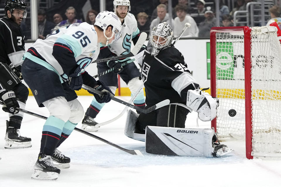 Seattle Kraken left wing Andre Burakovsky, second from left, scores on Los Angeles Kings goaltender Cam Talbot, right, during the third period of an NHL hockey game Wednesday, April 3, 2024, in Los Angeles. (AP Photo/Mark J. Terrill)