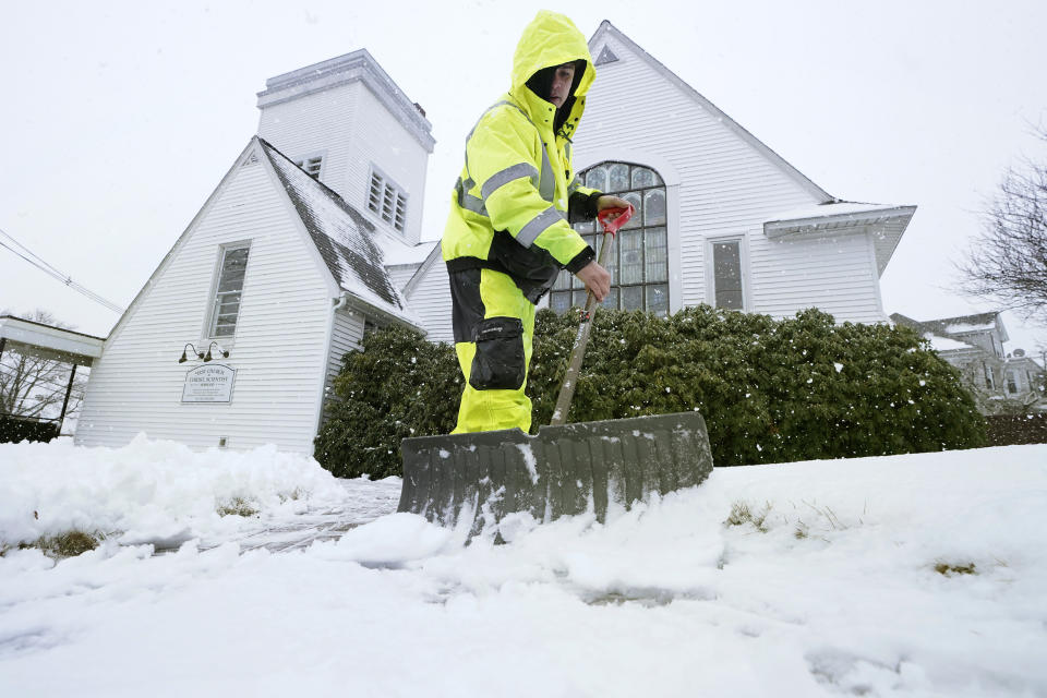 Worker Bayron Barrientos, of Providence, R.I., shovels snow off a path, Tuesday, Feb. 28, 2023, in front of a church, in Norwood, Mass. Parts of the Northeast are gearing up for what could be heavy snow Tuesday. (AP Photo/Steven Senne)