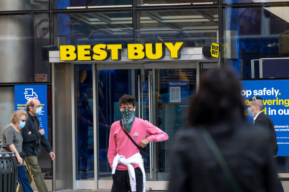 NEW YORK, NEW YORK - SEPTEMBER 30: People wearing masks pass by a Best Buy in Union Square as the city continues Phase 4 of re-opening following restrictions imposed to slow the spread of coronavirus on September 30, 2020 in New York City. The fourth phase allows outdoor arts and entertainment, sporting events without fans and media production. (Photo by Alexi Rosenfeld/Getty Images)