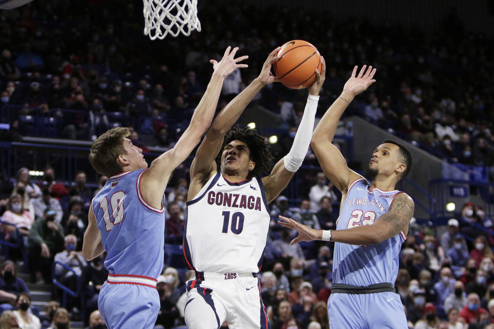 Gonzaga guard Hunter Sallis, center, shoots between Lewis-Clark State guard Sam Stockton, left, and forward Kevin Baker during the second half of a college basketball exhibition game, Friday, Nov. 5, 2021, in Spokane, Wash. (AP Photo/Young Kwak)