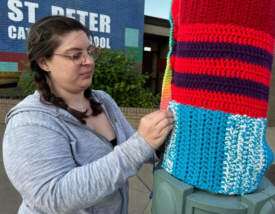 Massillon resident Natalie Starn works on yarn art on Sixth Street NW in downtown Canton. This is the second summer yarn art has decorated part of downtown.