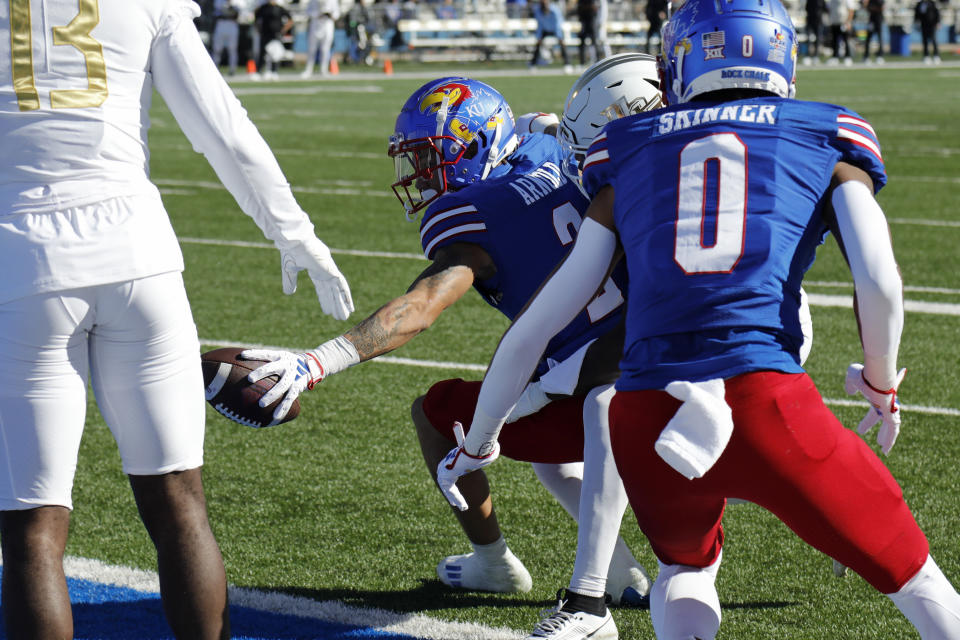 Kansas wide receiver Lawrence Arnold, center, reaches to score a touchdown during the first half of an NCAA college football game against Central Florida, Saturday, Oct. 7, 2023, in Lawrence, Kan. (AP Photo/Colin E. Braley)