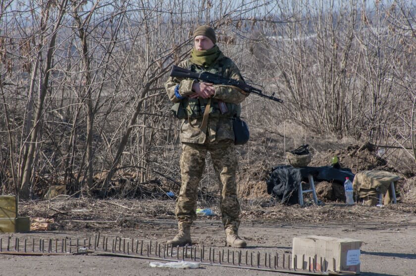 A Ukrainian serviceman guards his position in Kharkiv outskirts, Ukraine, Wednesday, March 23, 2022. (AP Photo/Andrew Marienko)