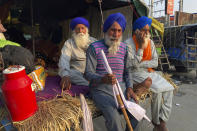 Indian farmers sit at the back of their tractor trawler as they block traffic at the Delhi-Haryana state border, Monday, Nov. 30, 2020. Indian Prime Minister Narendra Modi tried to placate thousands of farmers protesting new agriculture laws Monday and said they were being misled by opposition parties and that his government would resolve all their concerns. (AP Photo/Rishi Lekhi)