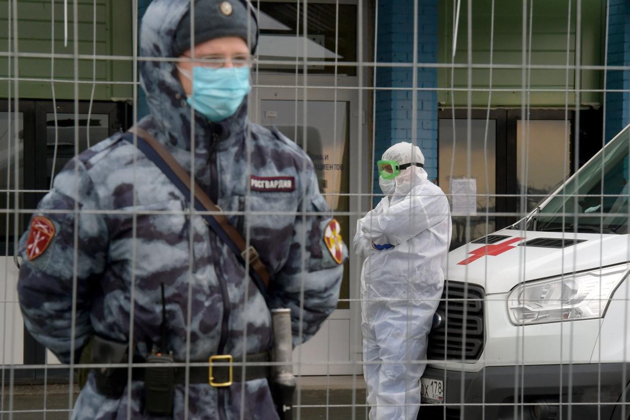 Russian National Guard and doctor stand outside Covid hospital in St Petersburg (AFP via Getty Images)