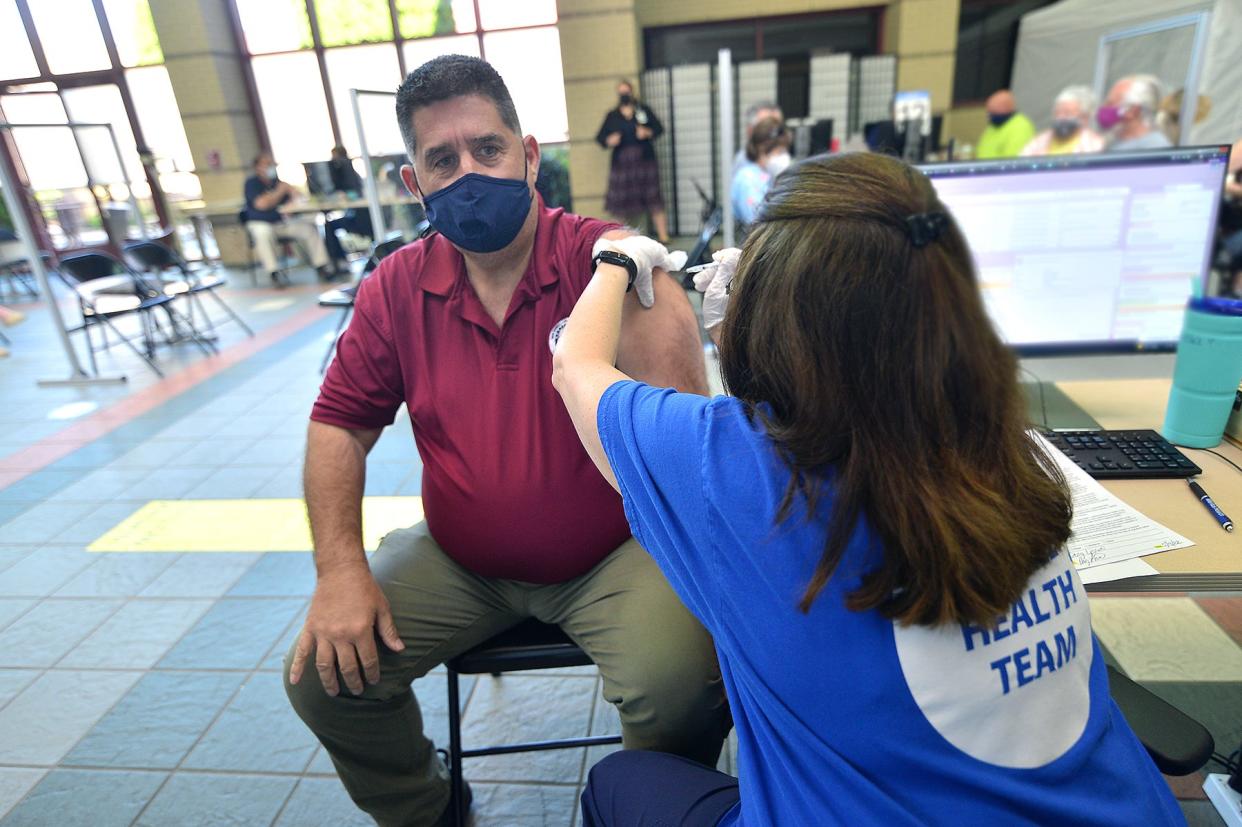 Doug Levine of Williamsport, Maryland, receives his second booster shot, which is also the 100,000th vaccine administered at the Meritus COVID-19 vaccination clinic at the Robinwood Professional Center near Hagerstown.