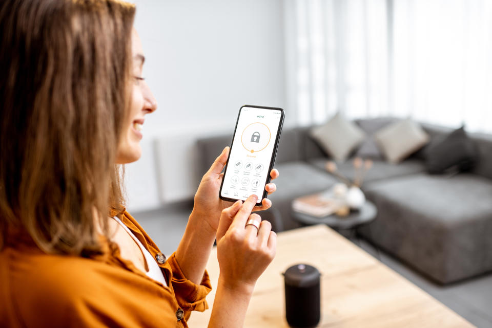 Mujer con su celular con aplicación de seguridad - Créditos: Gettyimages