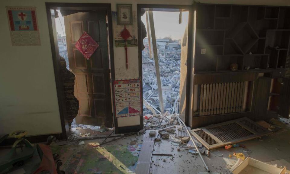 Demolished buildings seen from inside an abandoned dwelling in a migrant housing area on the outskirts of Beijing.