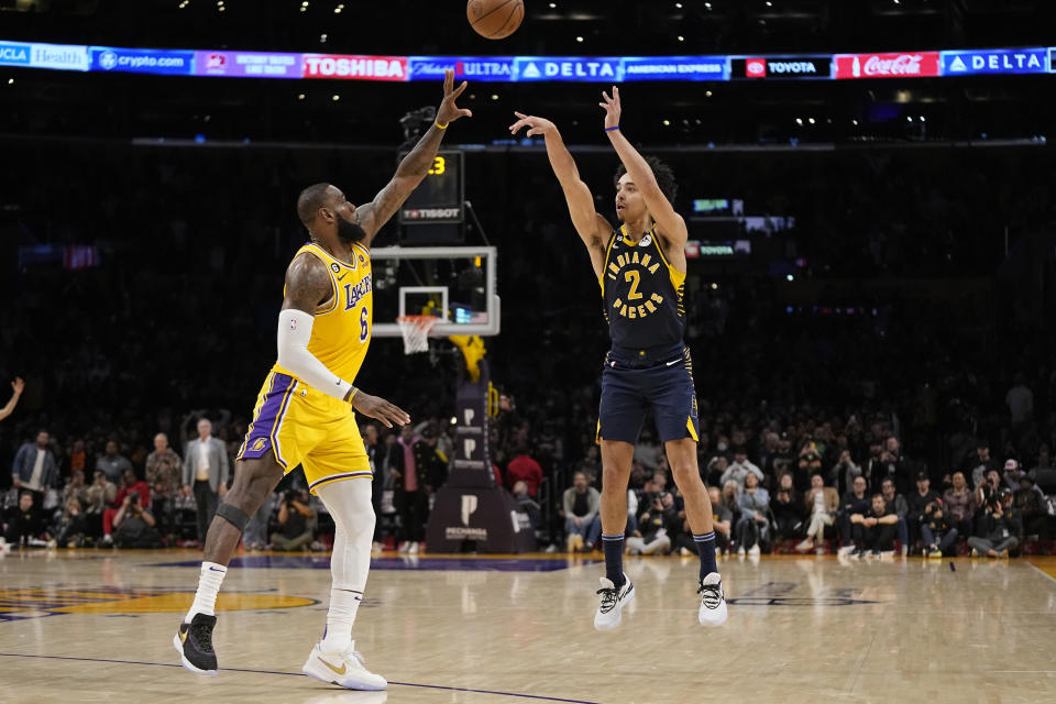 Indiana Pacers guard Andrew Nembhard, right, makes a buzzer beating 3-point shot to win the game as Los Angeles Lakers forward LeBron James defends during the second half of an NBA basketball game Monday, Nov. 28, 2022, in Los Angeles. The Pacers won 116-115. (AP Photo/Mark J. Terrill)