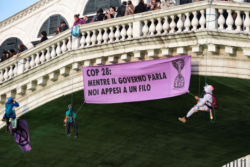 People hang a banner over Grand Canal during a protest by 'Extinction Rebellion' climate activists in Venice