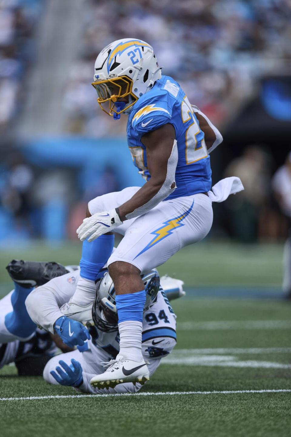 Chargers running back J.K. Dobbins (27) is tripped up by Panthers defensive end A'Shawn Robinson (94).