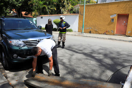 A man prepares to tow the car of Vanessa Mikuski in Caracas, Venezuela June 15, 2018. Picture taken June 15, 2018. REUTERS/Adriana Loureiro