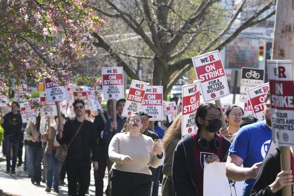 Strikers march in front of Rutgers' buildings in New Brunswick, N.J., Monday, April 10, 2023. Thousands of professors, part-time lecturers and graduate student workers at New Jersey's flagship university have gone on strike — the first such job action in the school's 257-year history. (AP Photo/Seth Wenig)