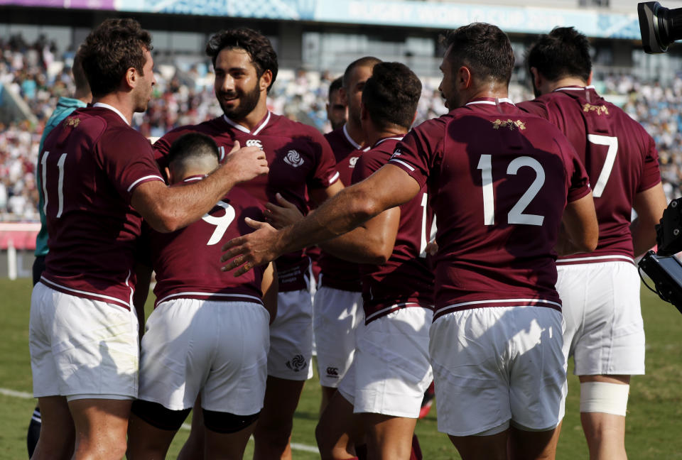 Georgia's Alexander Todua, left, is congratulated by teammates after scoring a try during the Rugby World Cup Pool D game at Kumagaya Rugby Stadium between Uruguay and Georgia in Kumagaya, Japan, Sunday, Sept. 29, 2019. (AP Photo/Shuji Kajiyama)