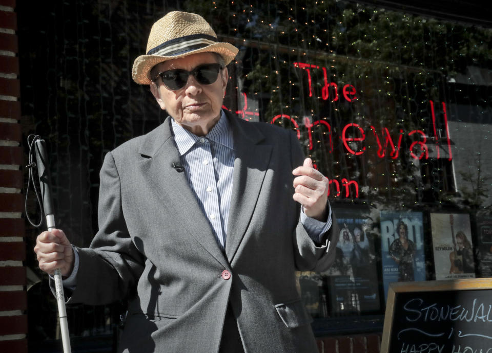 Karla Jay, a gay rights activist, author, gay and lesbian studies pioneer, prepares to interview outside The Stonewall Inn, Monday, June 3, 2019, in New York. In the wake of the 1969 uprising of gays following a New York Police Department raid at The Stonewall Inn bar, Jay was among hundreds mobilized by the nascent Gay Liberation Front who marched to the site, showing that gay people were mainstream. (AP Photo/Bebeto Matthews)