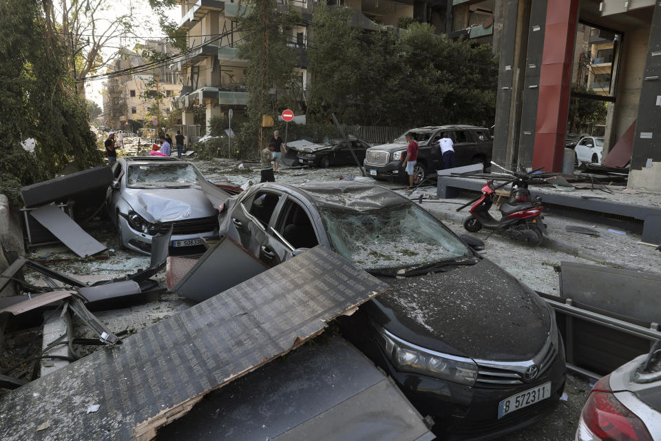 People inspect their damaged cars after a massive explosion on Tuesday, in Beirut, Lebanon, Wednesday, Aug. 5, 2020. The explosion flattened much of a port and damaged buildings across Beirut, sending a giant mushroom cloud into the sky. In addition to those who died, more than 3,000 other people were injured, with bodies buried in the rubble, officials said. (AP Photo/Bilal Hussein)