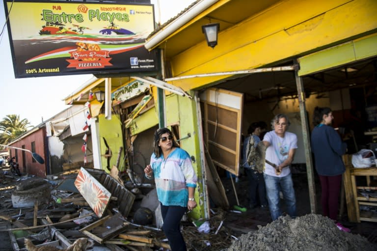 Residents remove debris in Tongoy, 400 kilometres north of Santiago, on September 17, 2015 as traumatized Chileans recounted a night of terrifying aftershocks after a powerful quake struck offshore the day before