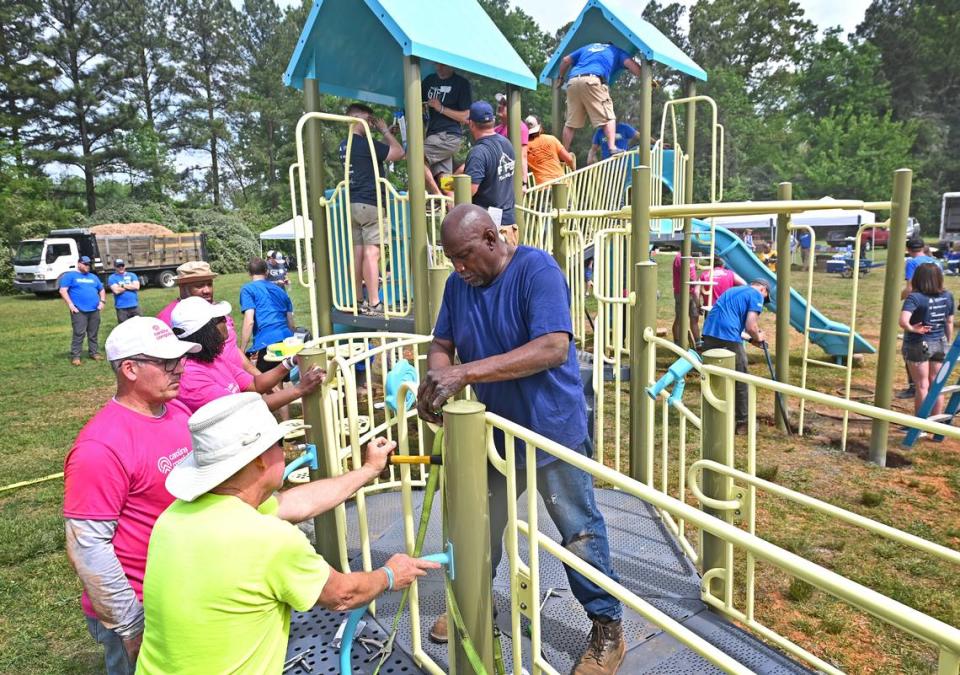 Volunteers work to build a piece of playground equipment at Westerly Hills Academy on Friday, April 19, 2024. Employees from local companies came together for the 19th Charlotte Playground Build. The playground build is presented by United Way of Greater Charlotte that brings together companies across the community to build a new playground for a local Charlotte-Mecklenburg elementary school.