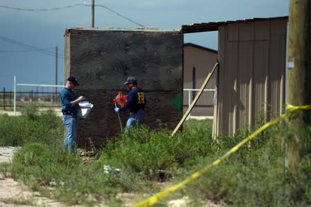 FBI agents investigate the home of Seth Ator following a shooting in Odessa
