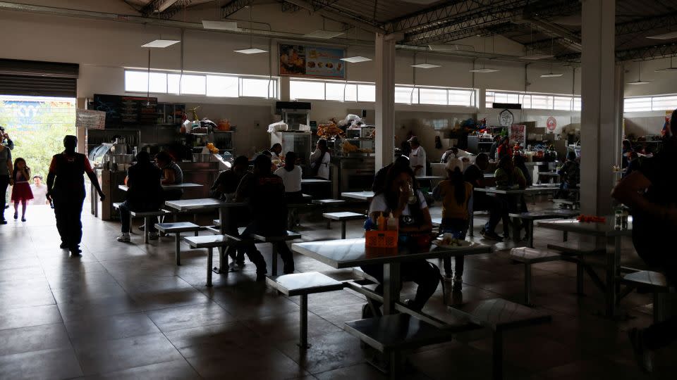 Customers eat in a darkened market square during a power cut in Quito, Ecuador, on April 18. - Karen Toro/Reuters
