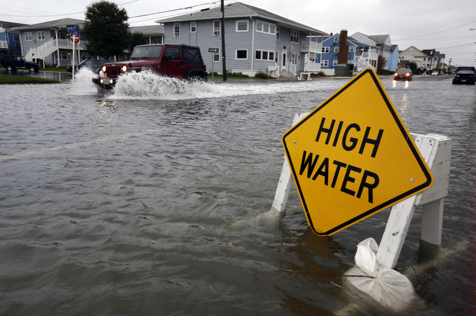 A car goes through the high water as Hurricane Sandy bears down on the East Coast, Sunday, Oct. 28, 2012, in Ocean City, Md. Governors from North Carolina, where steady rains were whipped by gusting winds Saturday night, to Connecticut declared states of emergency. Delaware ordered mandatory evacuations for coastal communities by 8 p.m. Sunday. (AP Photo/Alex Brandon)