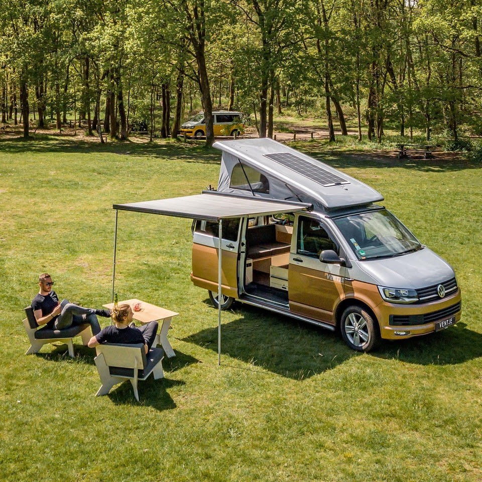 Couple relaxes on folding chairs outside the Ventje while its impressive solar panel system soaks up some power. 