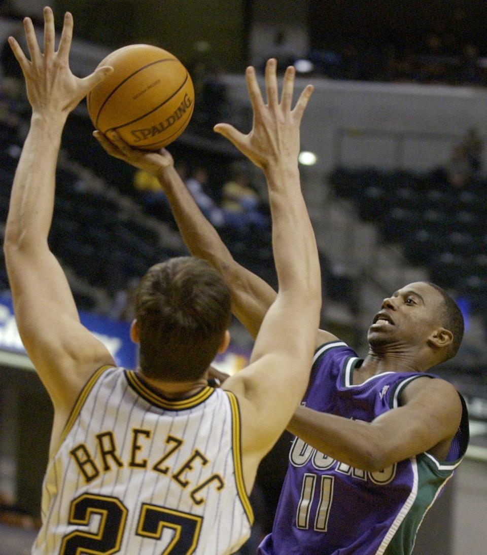 Milwaukee Bucks guard T.J. Ford (11) puts up a shot over Indiana Pacers center Primoz Brezec of Slovenia during the fourth quarter in Indianapolis, Friday, Oct. 31, 2003. Ford had 11 points, 11 rebounds and seven assists in the Bucks' 93-79 win. (AP Photo/Darron Cummings)
