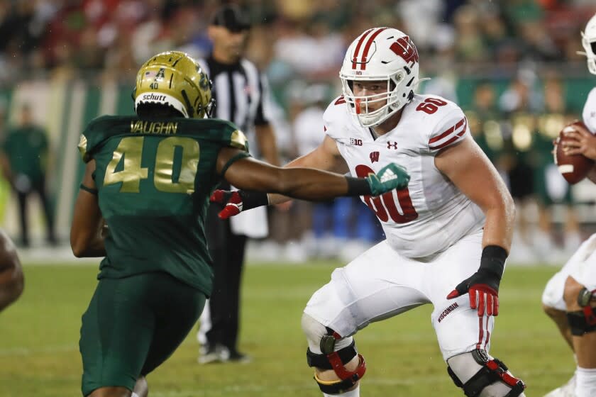 Wisconsin Badgers offensive lineman Logan Bruss (60) blocks South Florida Bulls defensive end Jason Vaughn (40) during an NCAA football game on Friday, Aug. 30, 2019 in Tampa, Fla. (AP Photo/Mark Lomoglio)