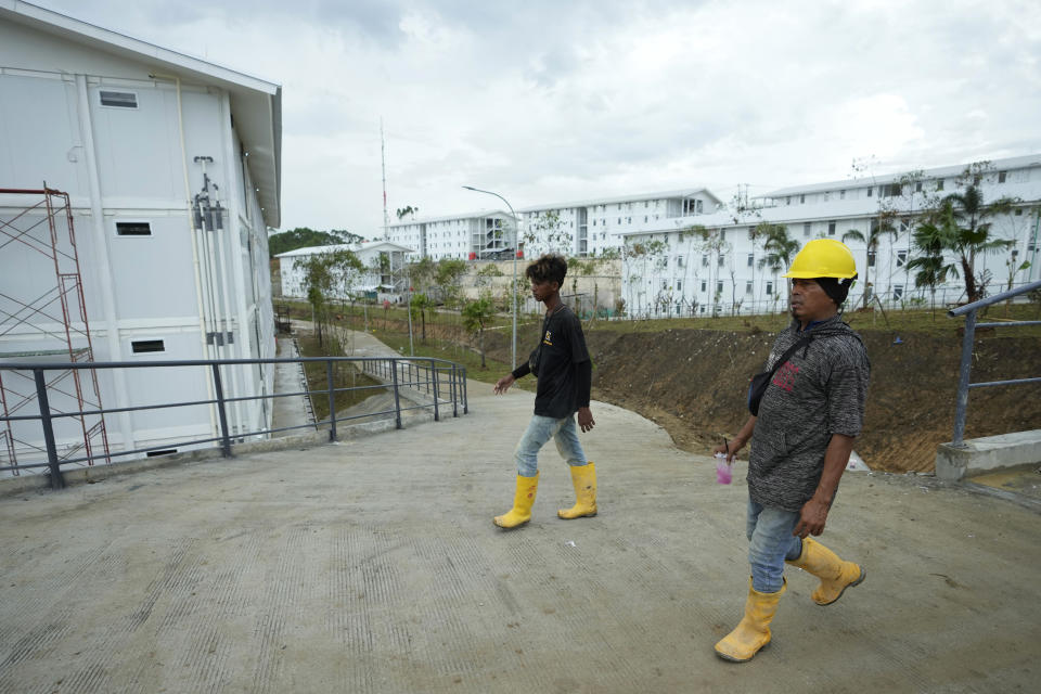 Workers walk at the construction site of the new capital city in Penajam Paser Utara, East Kalimantan, Indonesia, Wednesday, March 8, 2023. Indonesia began construction of the new capital in mid 2022, after President Joko Widodo announced that Jakarta — the congested, polluted current capital that is prone to earthquakes and rapidly sinking into the Java Sea — would be retired from capital status. (AP Photo/Achmad Ibrahim)