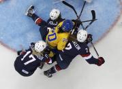 Sweden's Fanny Rask (C) is squeezed out by three Team USA players during the third period of their women's semi-final ice hockey game at the Sochi 2014 Winter Olympic Games, February 17, 2014. REUTERS/Mark Blinch (RUSSIA - Tags: OLYMPICS SPORT ICE HOCKEY)