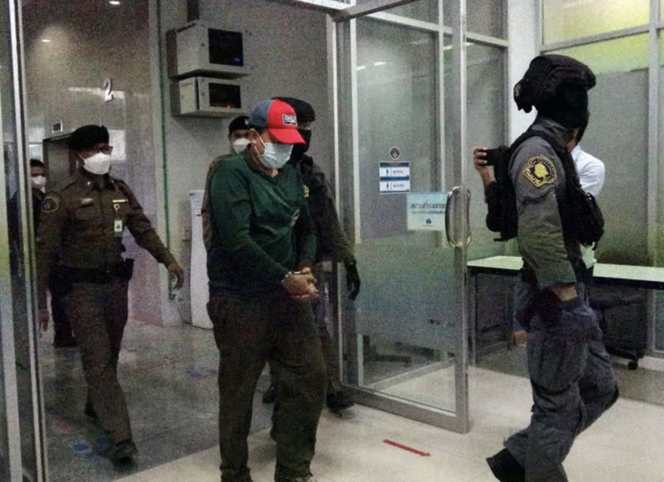在台灣犯下雙屍命案的王姓嫌犯17日在清邁向泰國警方投案，泰國警方接著將王姓嫌犯（紅帽者）帶到曼谷的犯罪防治處。

中央社記者呂欣憓曼谷攝 111年6月17日