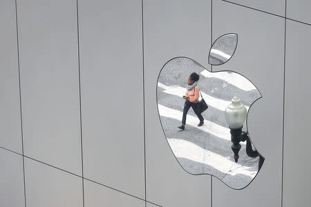 A woman is reflected in a Apple store logo in San Francisco, California, U.S., August 21, 2017. REUTERS/Kevin Coombs/Files