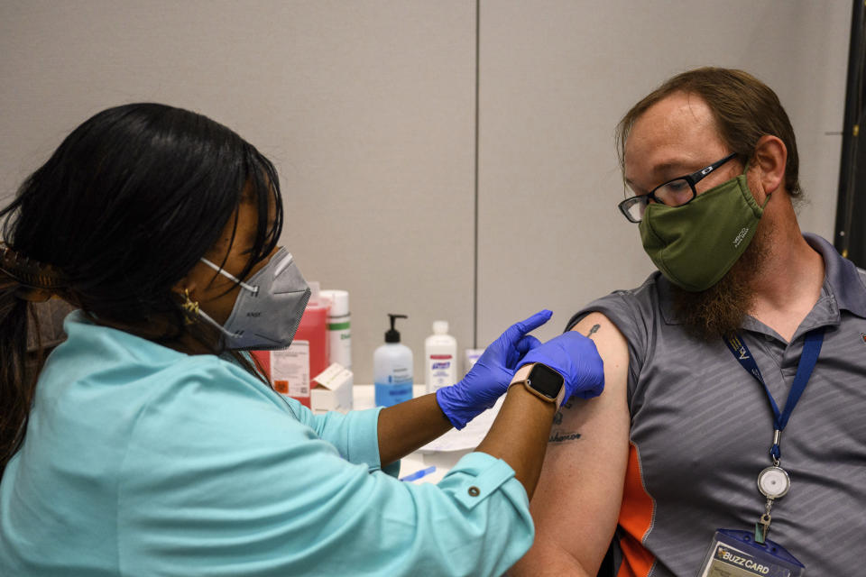 Georgia Tech employee Adam Jackson receives a Pfizer COVID-19 vaccination at the Vaccination Site on the campus of Georgia Tech on Thursday, April 8, 2021 in Atlanta. U.S. colleges hoping for a return to normalcy next fall are weighing how far they should go in urging students to get the COVID-19 vaccine, including whether they should — or legally can — require it. There’s a parallel debate about whether to require vaccination for faculty and staff, an issue that employers across the nation are grappling with. (AP Photo/Danny Karnik)