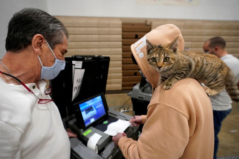 Barton Foley, de 32 años, con su gato "Little Ti Ti" en el hombro, emite su voto el día de las elecciones en la escuela secundaria Ballard en Louisville, Kentucky, EEUU