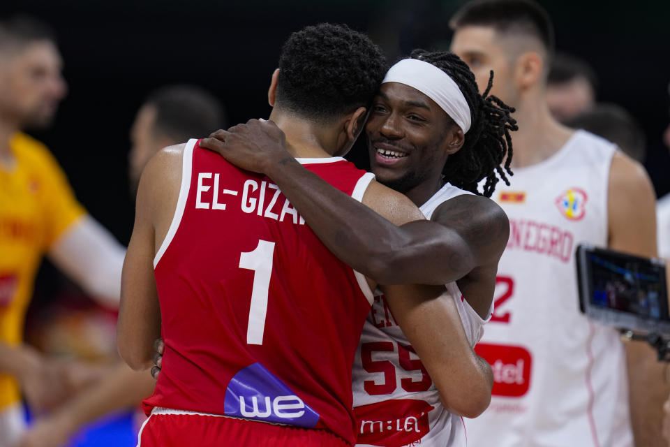 Montenegro guard Kendrick Perry (55) hugs Egypt guard Karim Elgizawy (1) following a Basketball World Cup group C match in Manila, Philippines Sunday, Aug. 27, 2023. Montenegro defeated Egypt 89-74. (AP Photo/Michael Conroy)